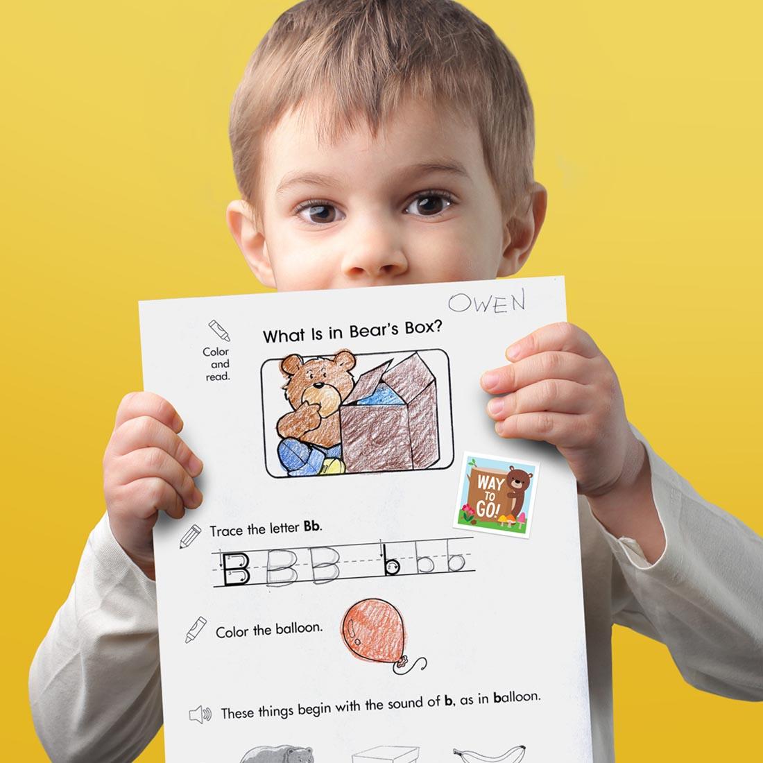 child holding a paper that has a Reward Sticker from the Woodland Friends collection by Creative Teaching Press on it
