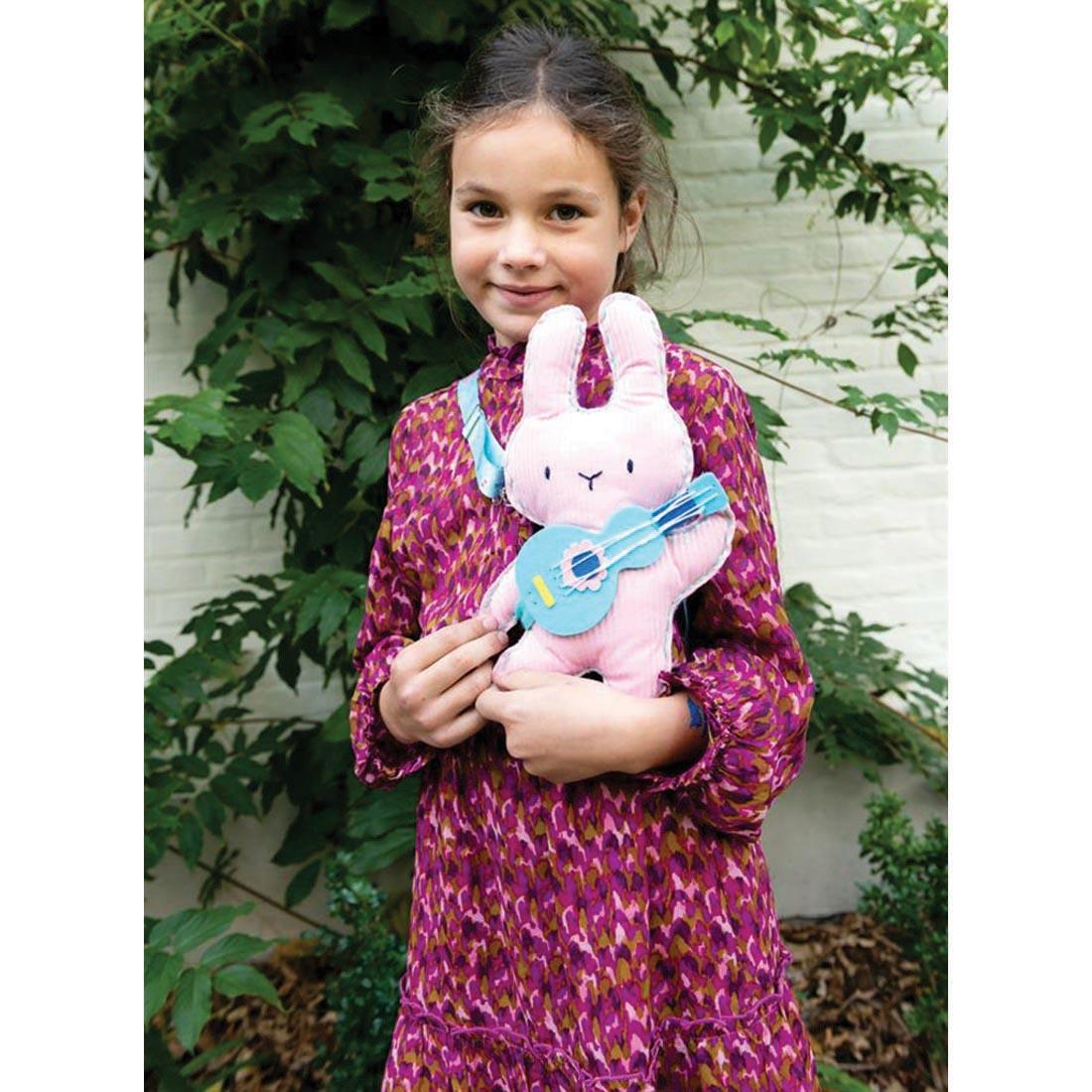 child holding a completed Musical Bunny My Animal Friend Sewing Kit By Avenir