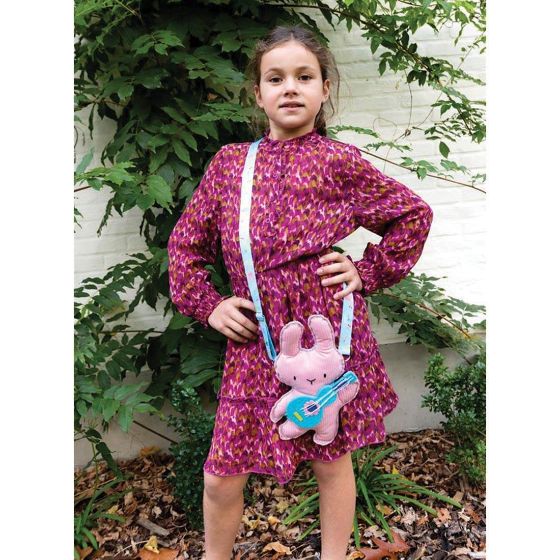child wearing a completed Musical Bunny My Animal Friend Sewing Kit By Avenir on its strap