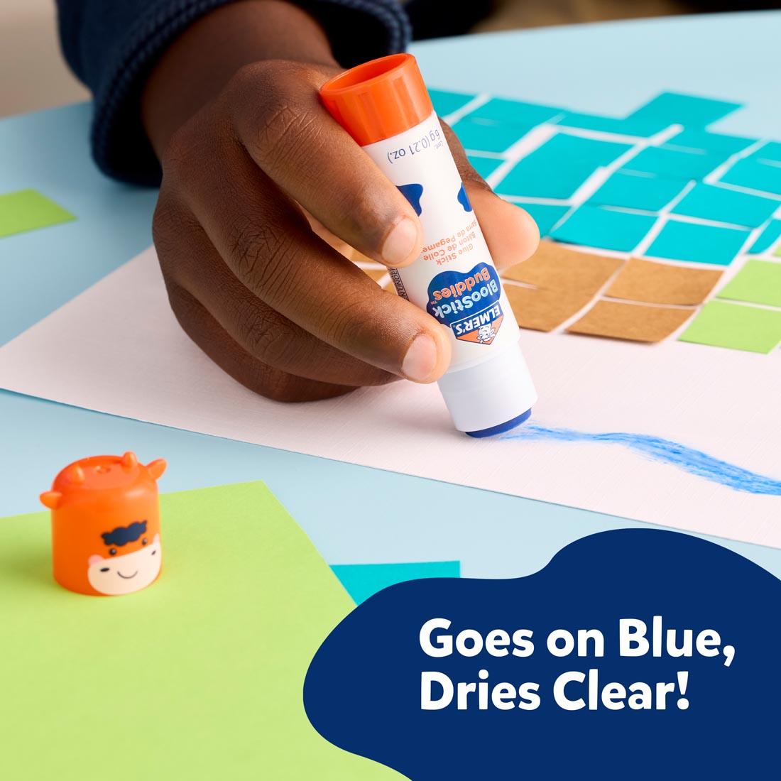 child's hand using an Elmer's BlooStick Buddies Washable Glue Stick plus text Goes on Blue, Dries Clear!