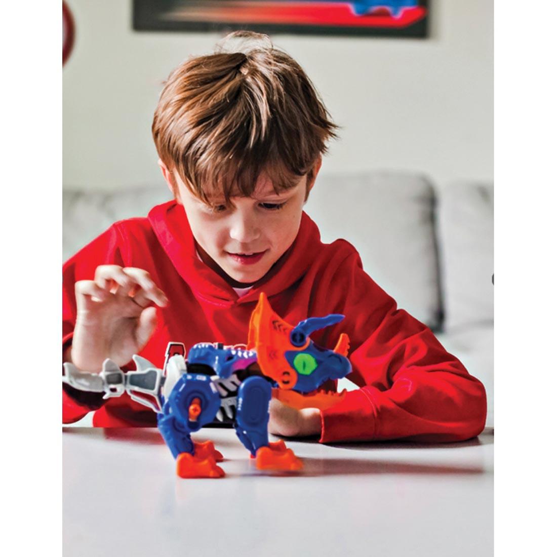 child playing with a completed Teach Tech Triceratops Robot
