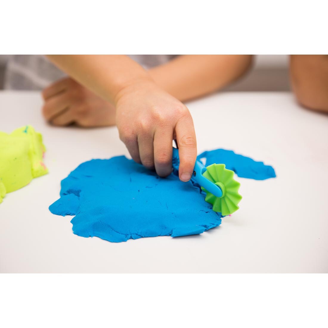 Child cutting Playfoam Sand with rolling cutter