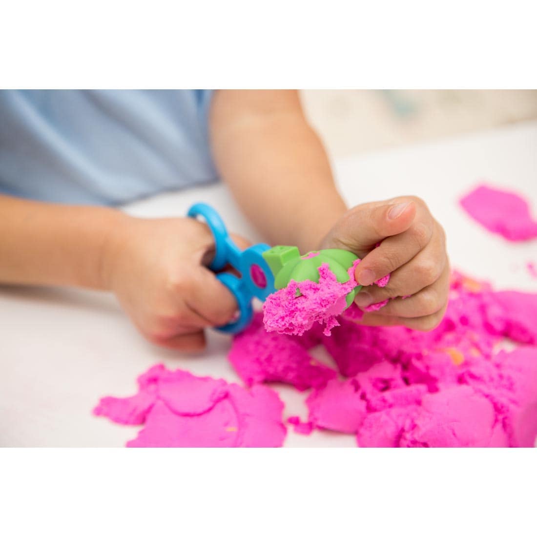 Child using scissor mold with Playfoam sand