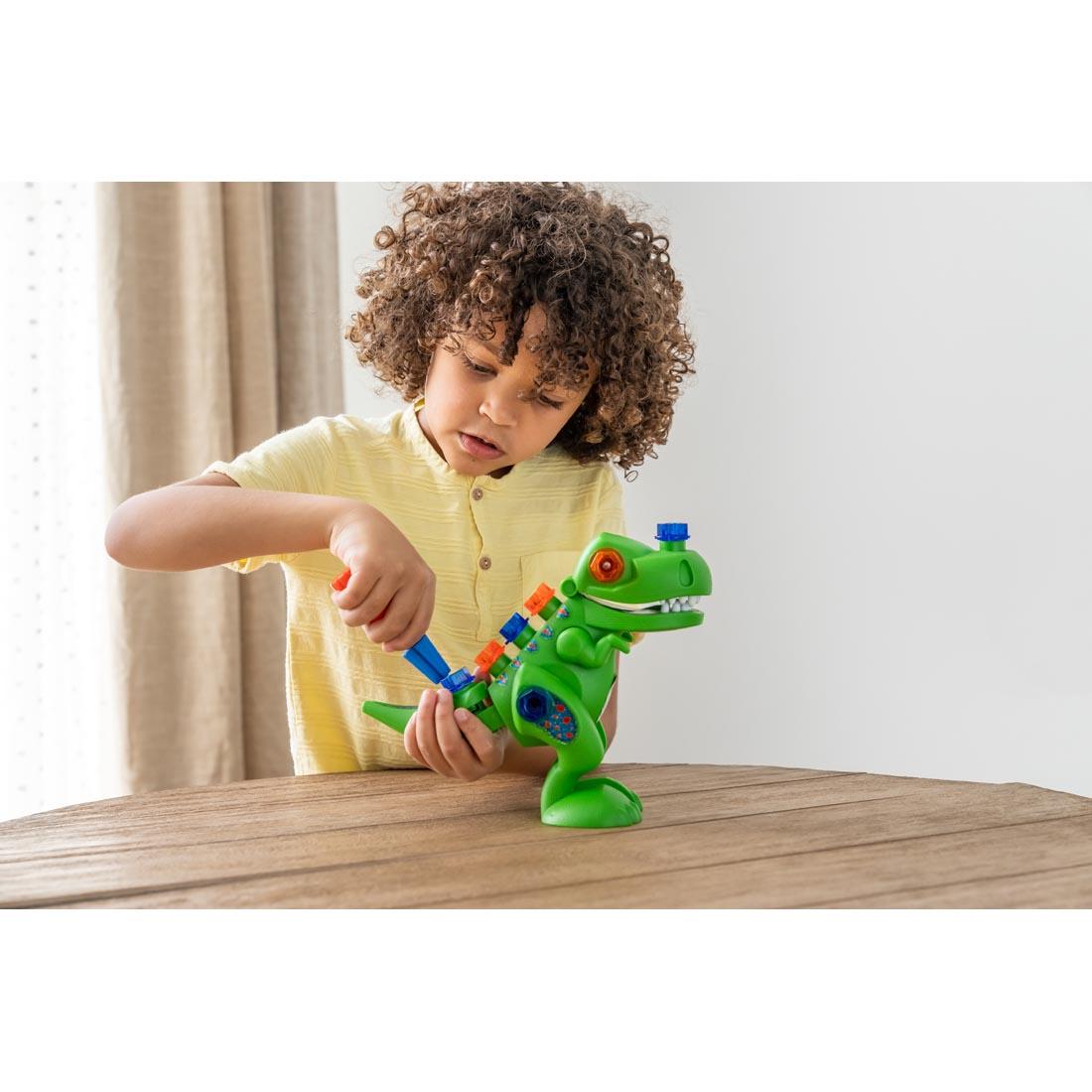 Child assembling Design & Drill T-Rex By Educational Insights