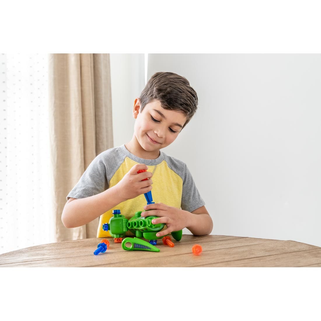 Child assembling Design & Drill T-Rex By Educational Insights