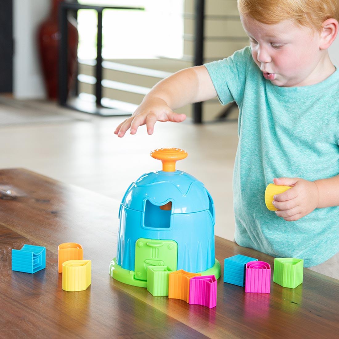 child playing with the Shape Factory By Fat Brain Toys