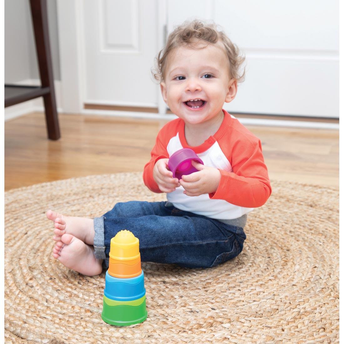 child sitting on the floor playing with Dimpl Stack pieces