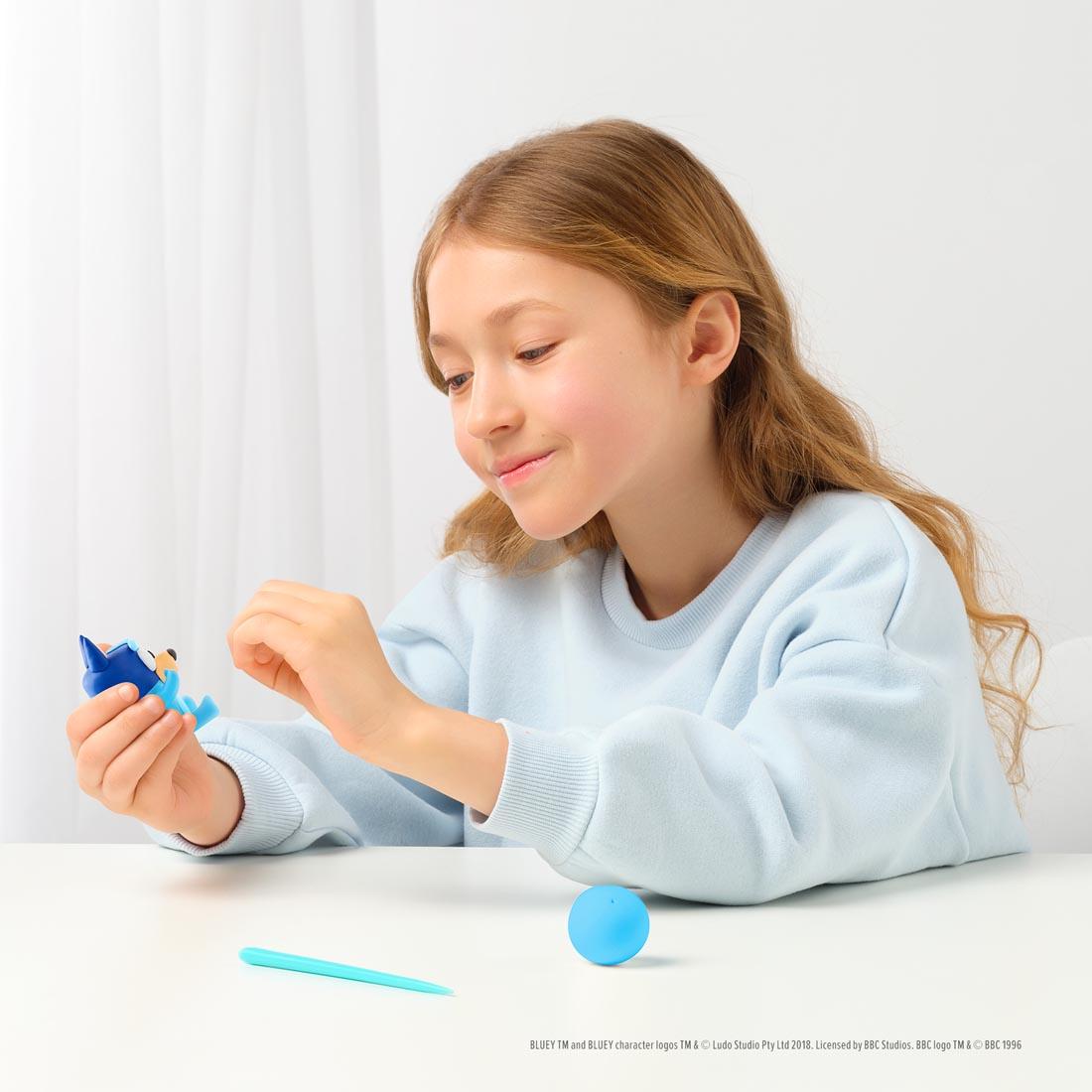 child using the Hey Clay Bluey & Friends Set By Fat Brain Toys