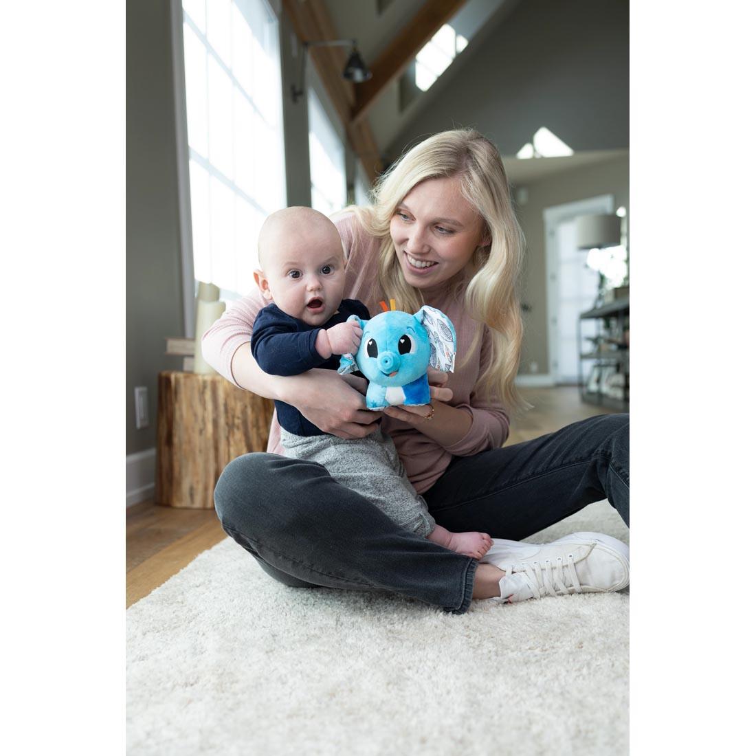 adult and baby sitting on the floor holding the Puffaboo Elephant By Lamaze