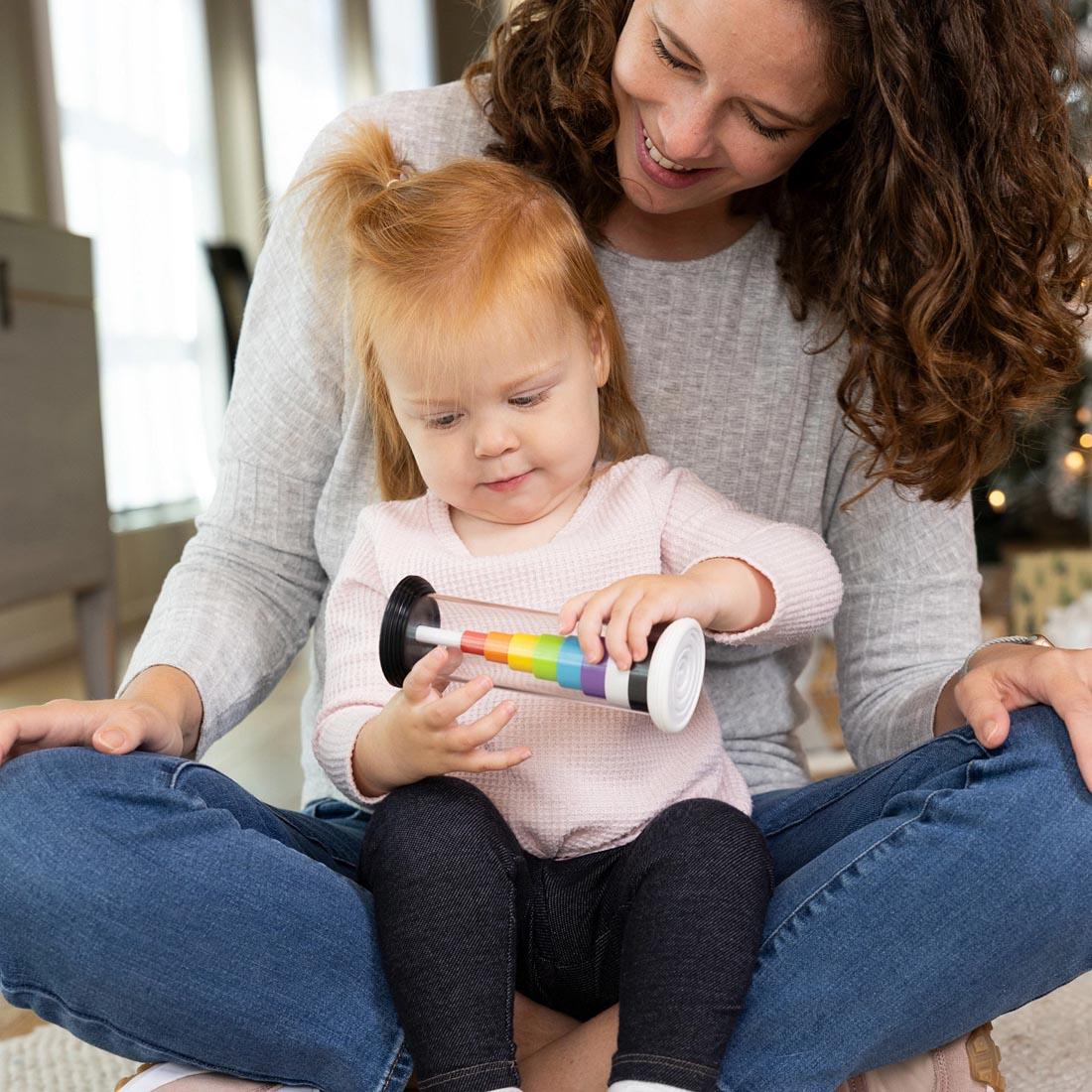 adult holding a child using the Flipty Toy By Fat Brain Toys