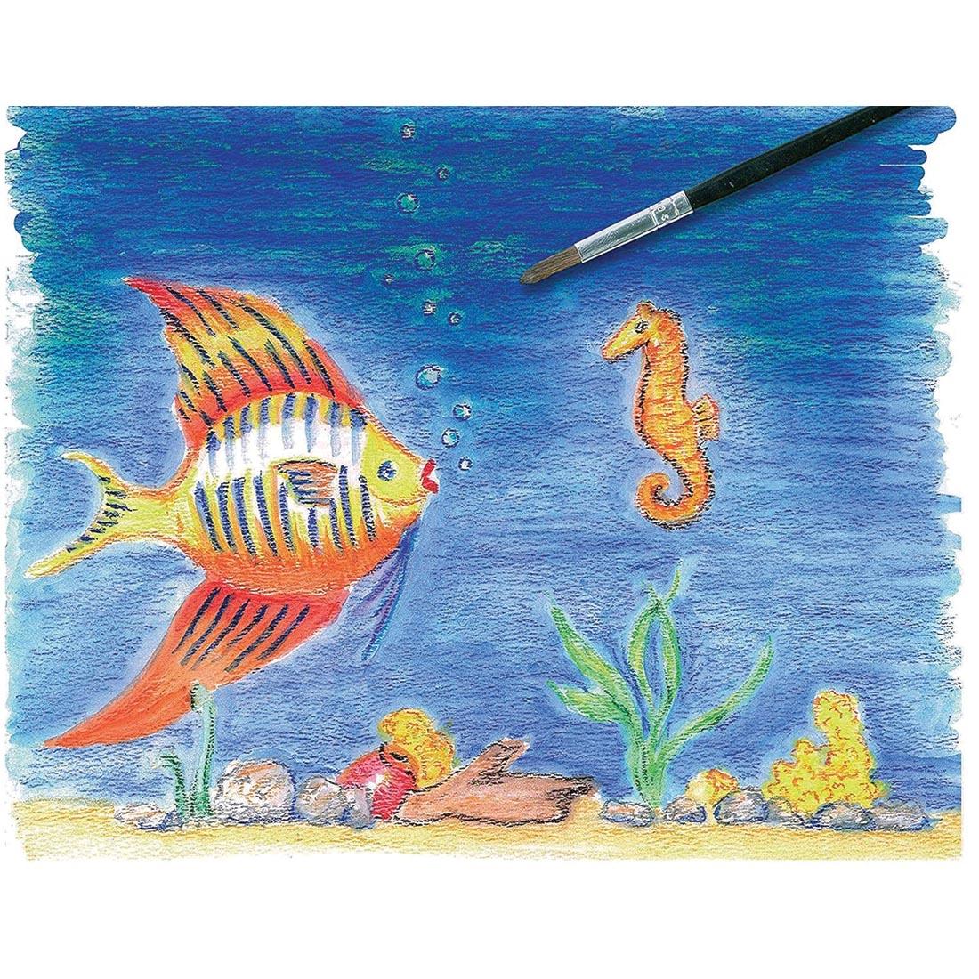 Sample artwork made with Faber-Castell watercolor crayons; paper shows a fish and seahorse under the sea, with a paintbrush near the top of the picture