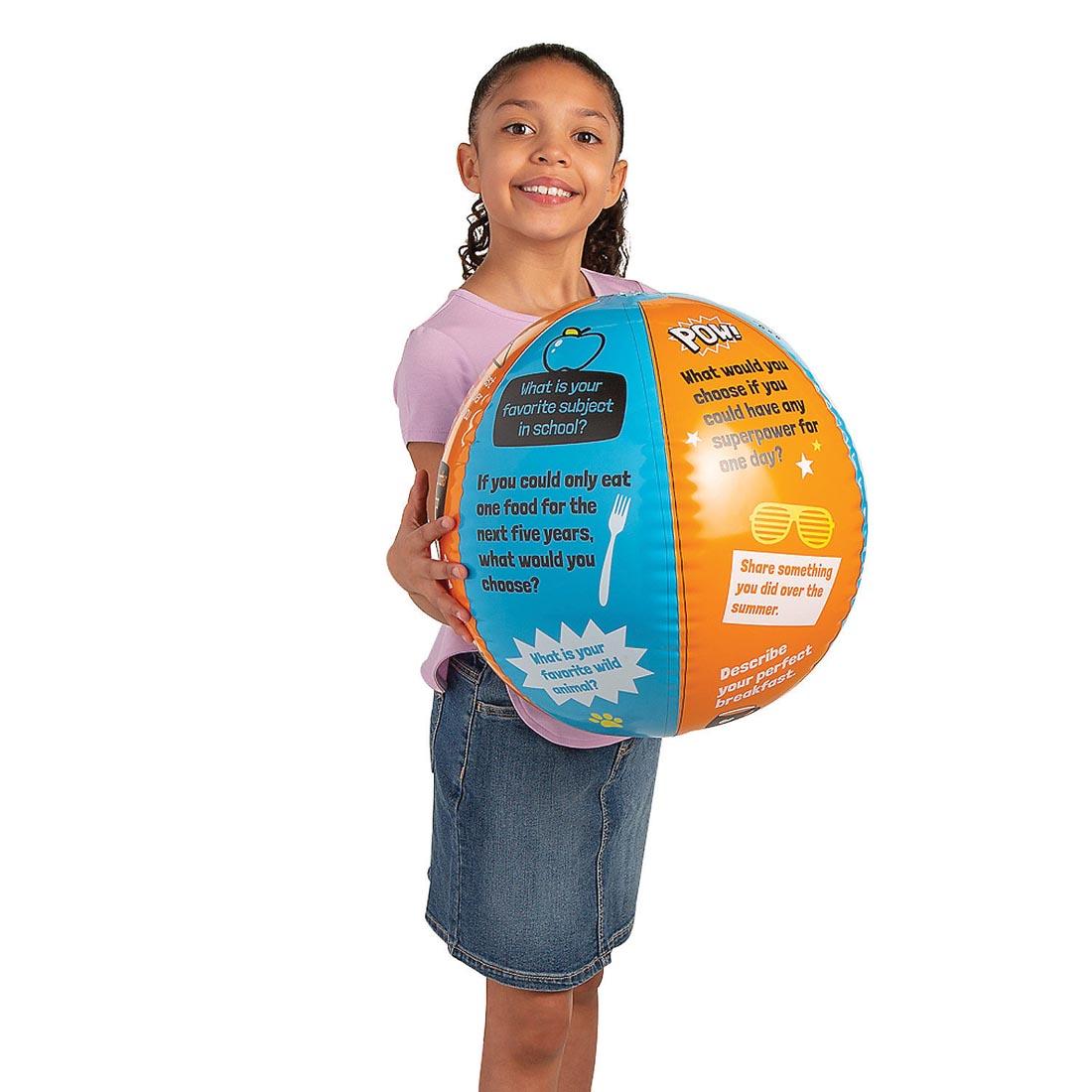 child holding an inflated All About Me Ice Breaker Beach Ball By Fun Express