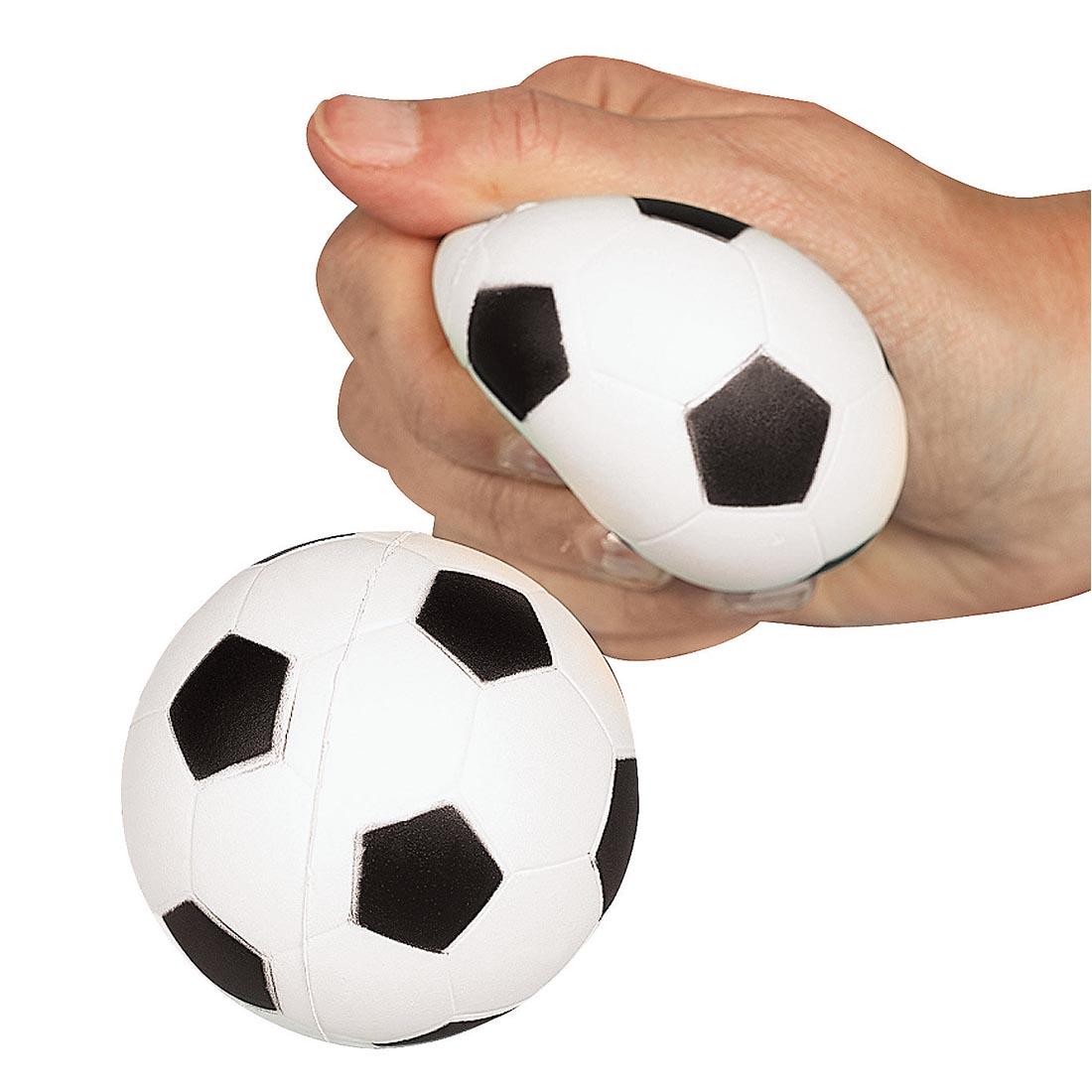 two Foam Realistic Soccer Stress Balls by Fun Express with a hand squeezing one of them