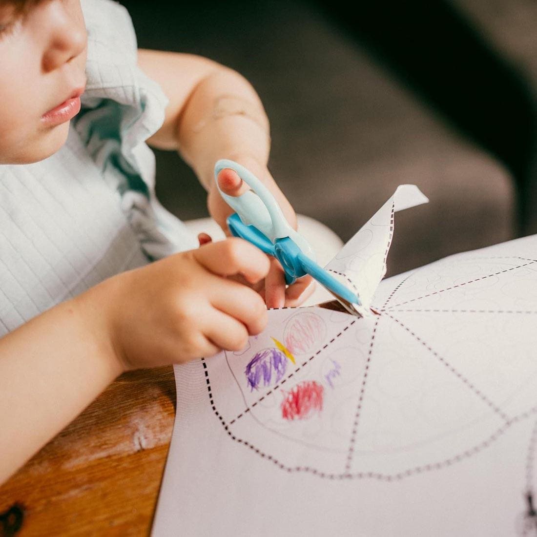 child using the Fiskars Cut & Learn Activity Book and Scissors Set for ages 3+