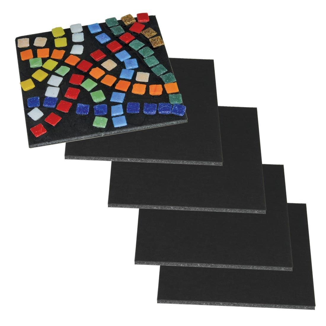 Five Black Flipside Foam Board 5x5" Sheets, one with a mosaic tile craft on top