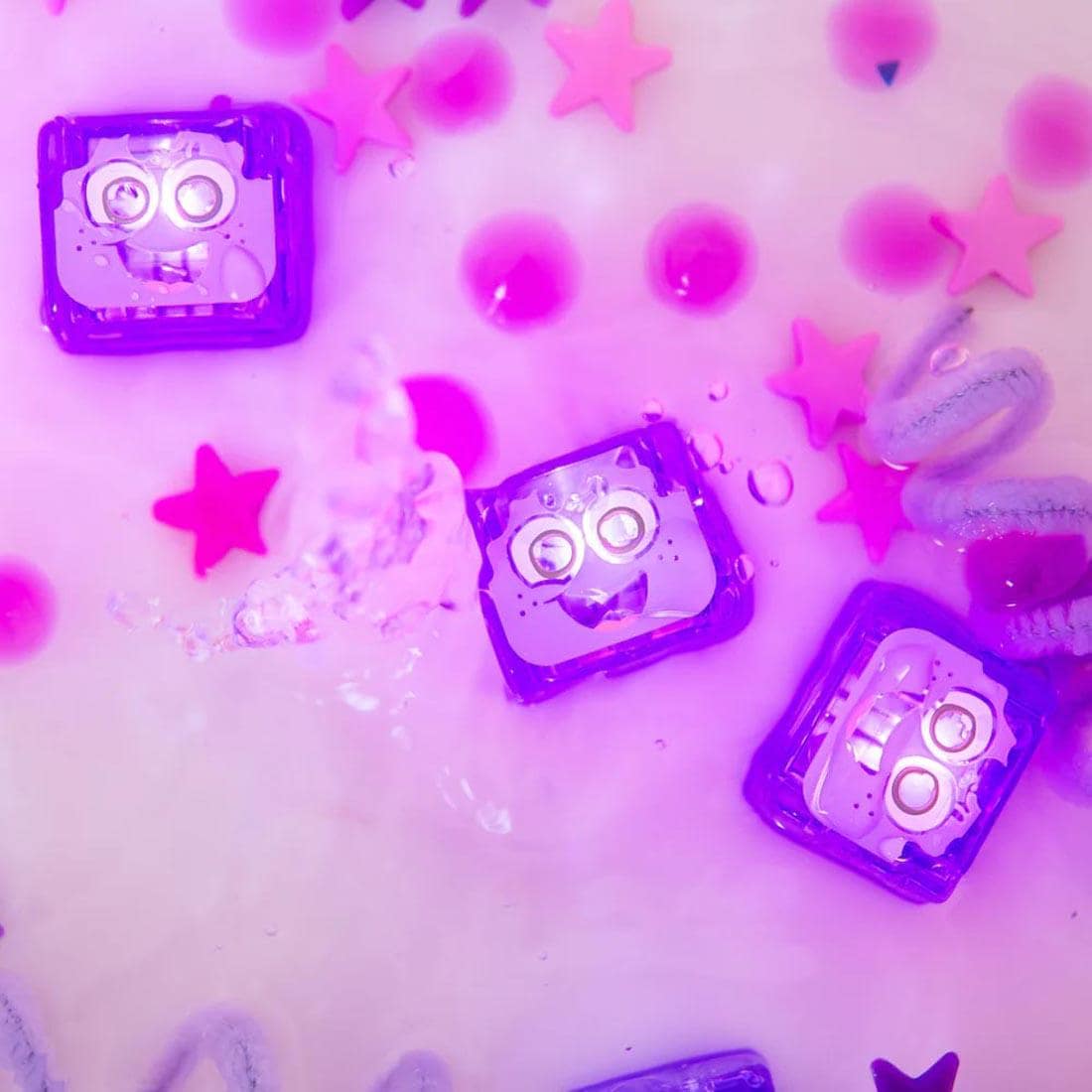 Hand dipping a Lumi Purple Glo Pals Water-Activated Light Up Cube into water