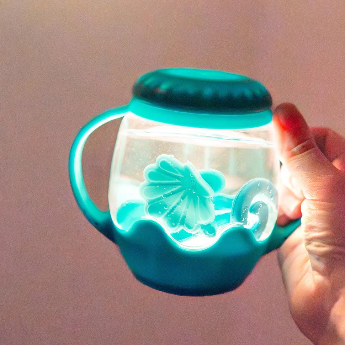 hand holding a Blue Lagoon Mini Sensory Play Jar By Glo Pals