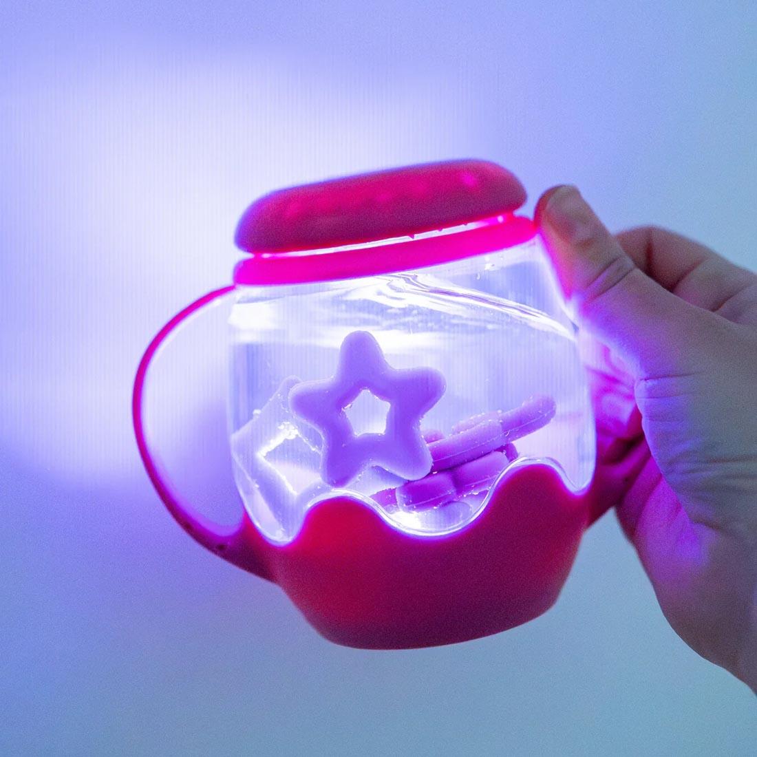 hand holding the Gumdrop Pink Mini Sensory Play Jar By Glo Pals