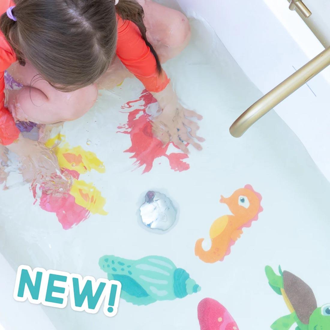 child in bathtub using Glow-In-The-Dark Guppy Grips Non-Slip Bathtub Stickies By Glo Pals plus text New!