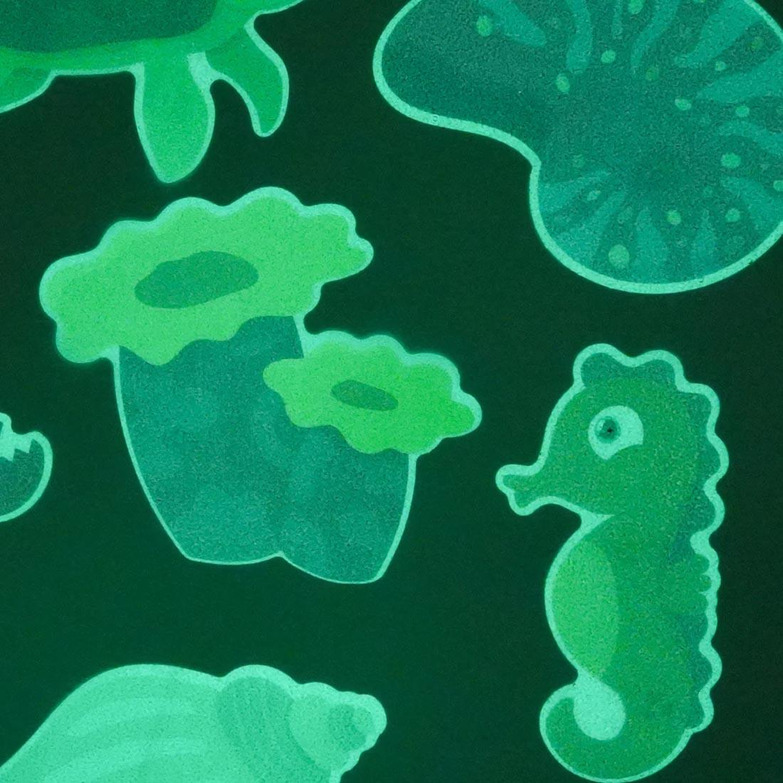 pieces from the Glow-In-The-Dark Guppy Grips Non-Slip Bathtub Stickies By Glo Pals glowing in the dark