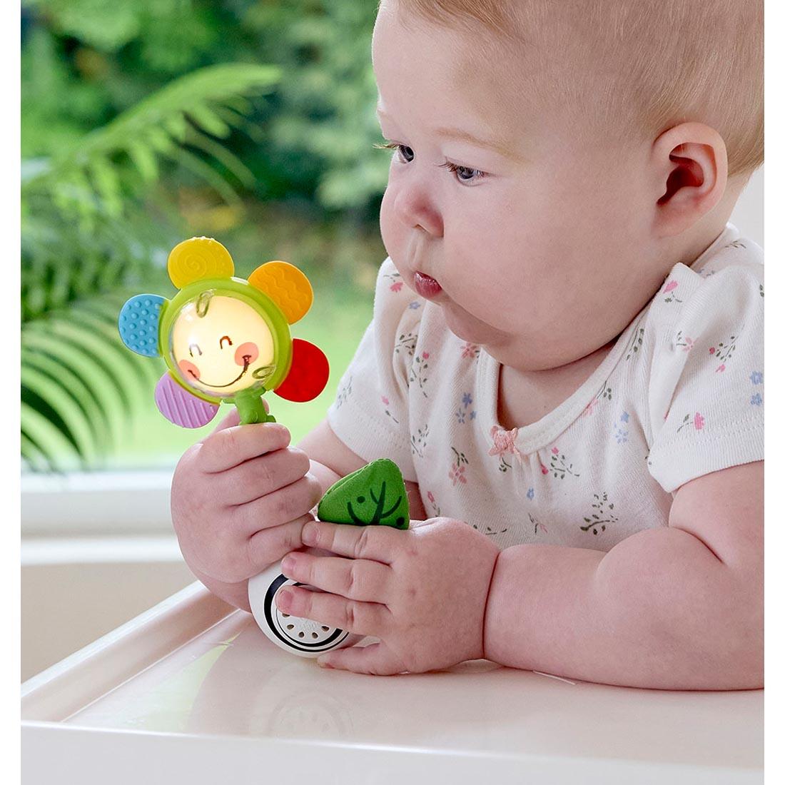 baby grasping the Shake 'N Sparkle Flower Rattle