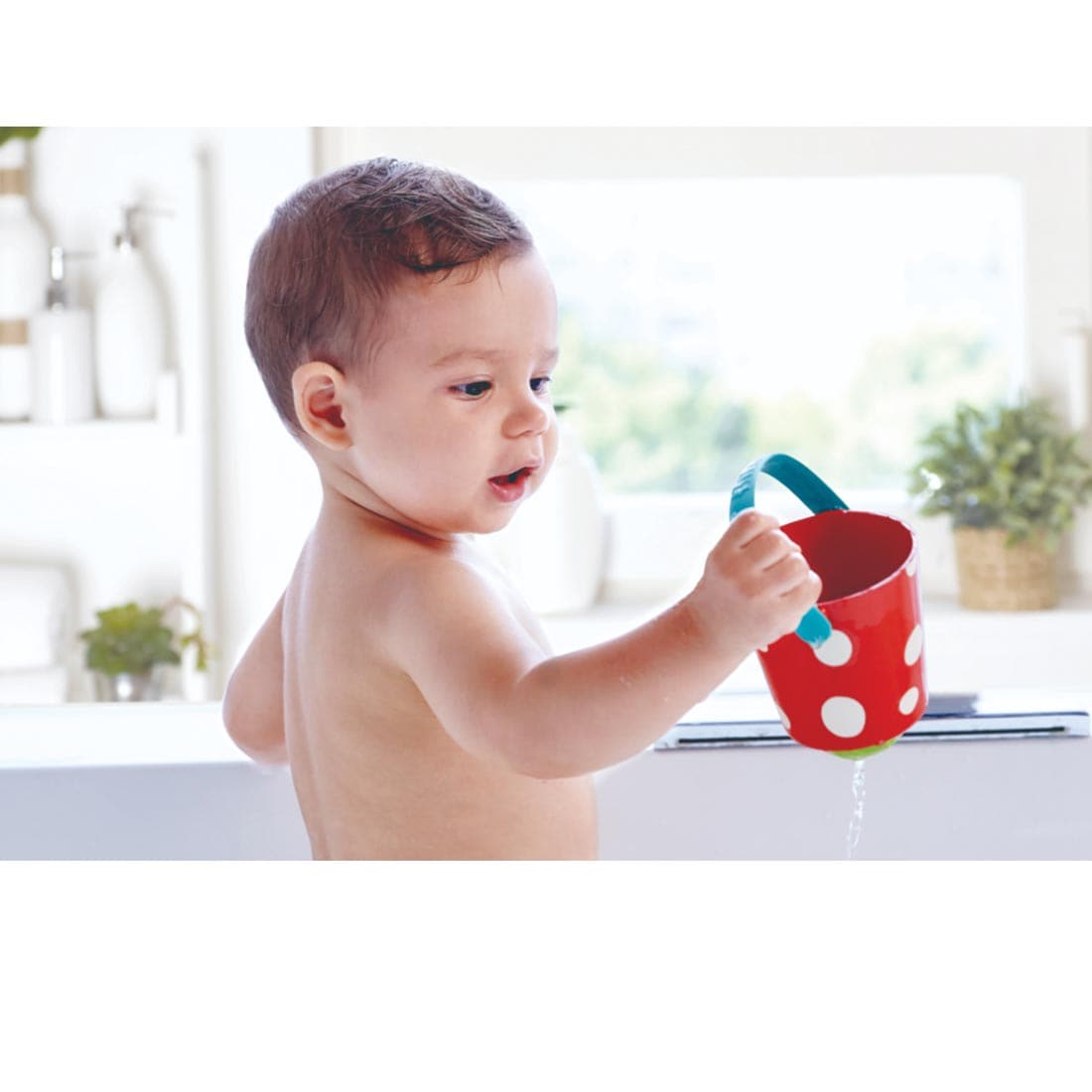 Baby holding one of the happy buckets from the Happy Buckets Set By Hape