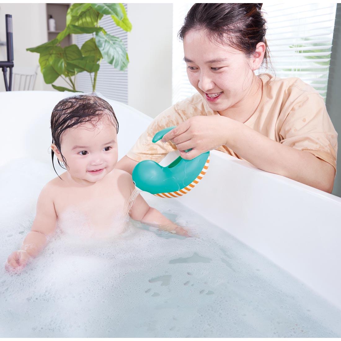 adult pouring water on a child in the bathtub with the Happy Splashers Seal Jug
