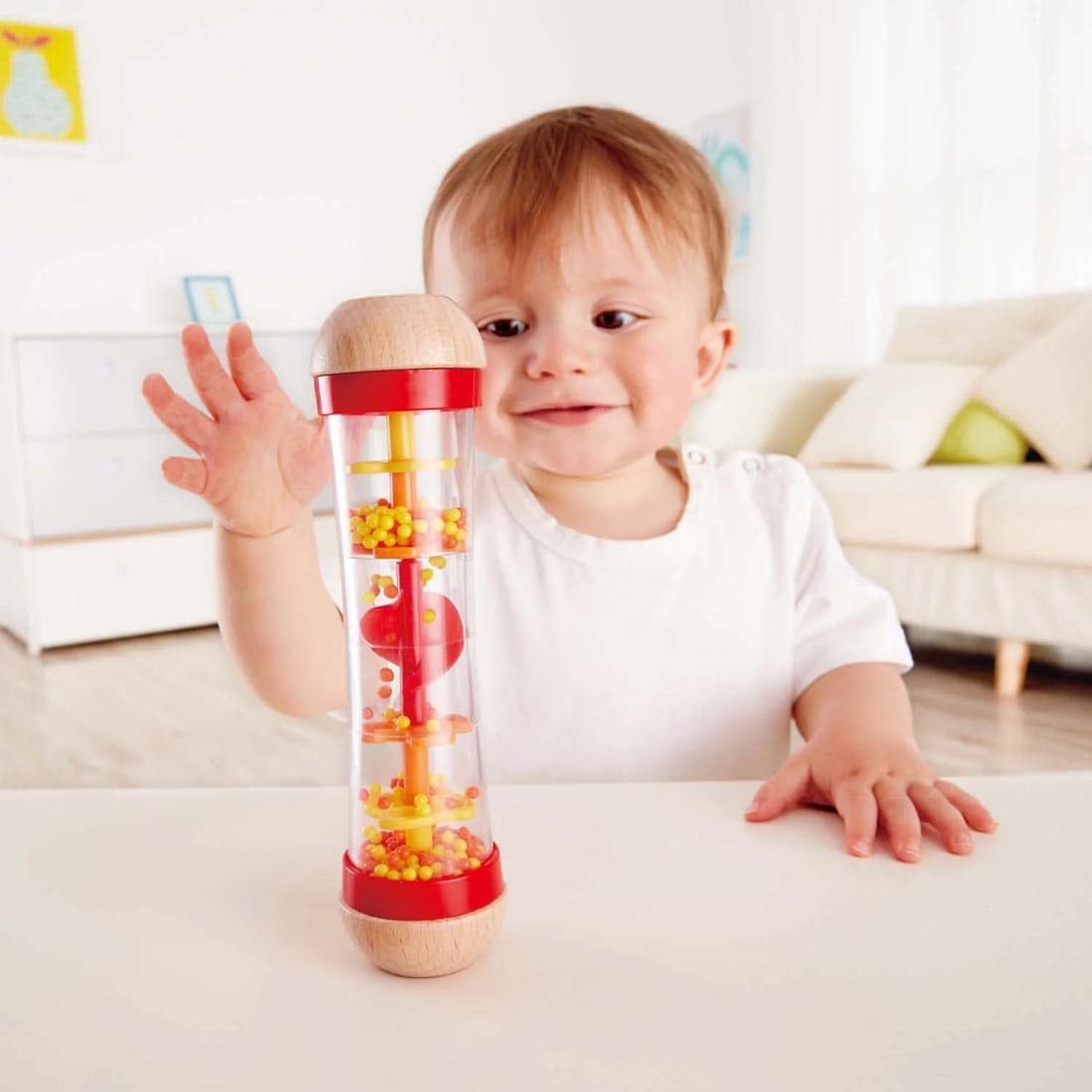 Child at a table playing with the Red Beaded Raindrops By Hape