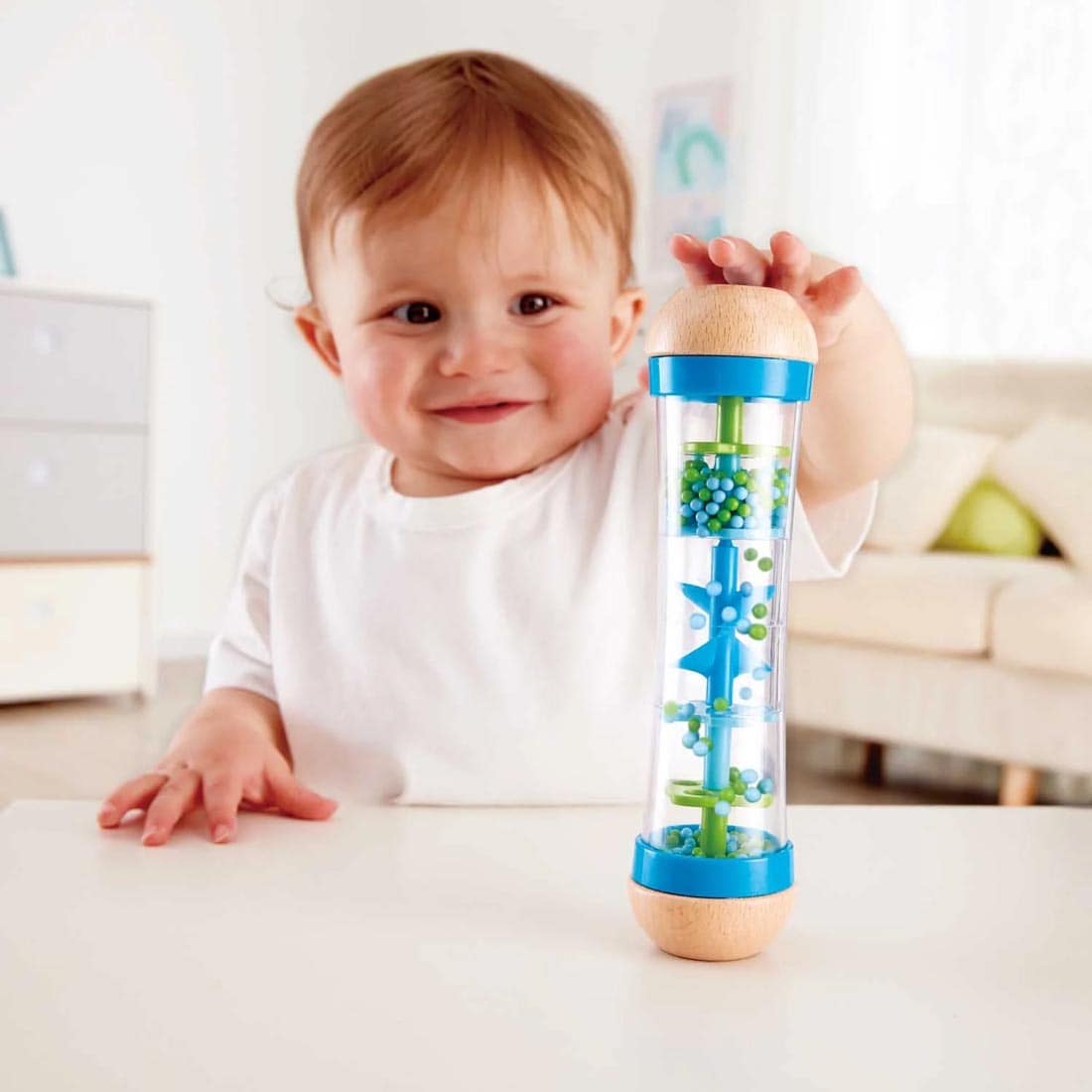 Child at a table playing with the Blue Beaded Raindrops By Hape