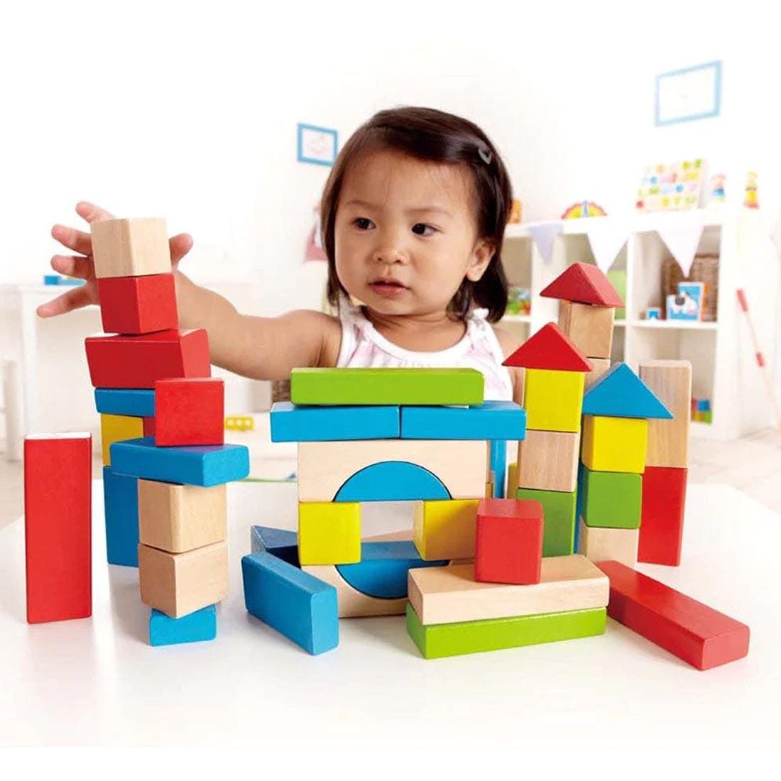 Child building with the 50-Piece Maple Wood Kids Building Blocks By Hape