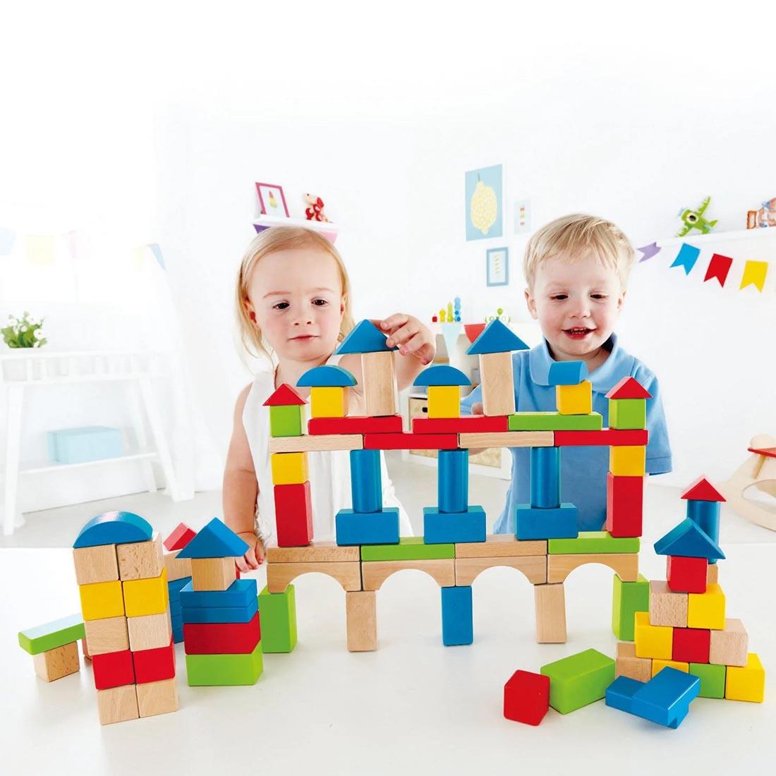 2 children building a structure with the 100-Piece Build Up And Away Blocks By Hape