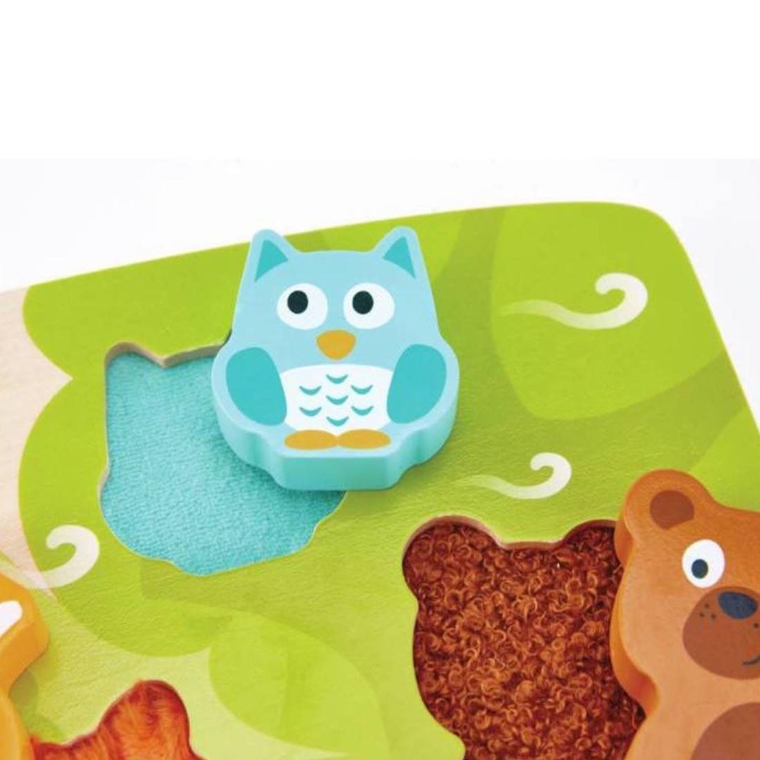 closeup of the Hape Forest Animal Tactile Puzzle to show two of the textures under the puzzle pieces