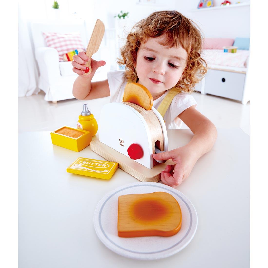 child playing with the Hape Pop-Up Toaster Set