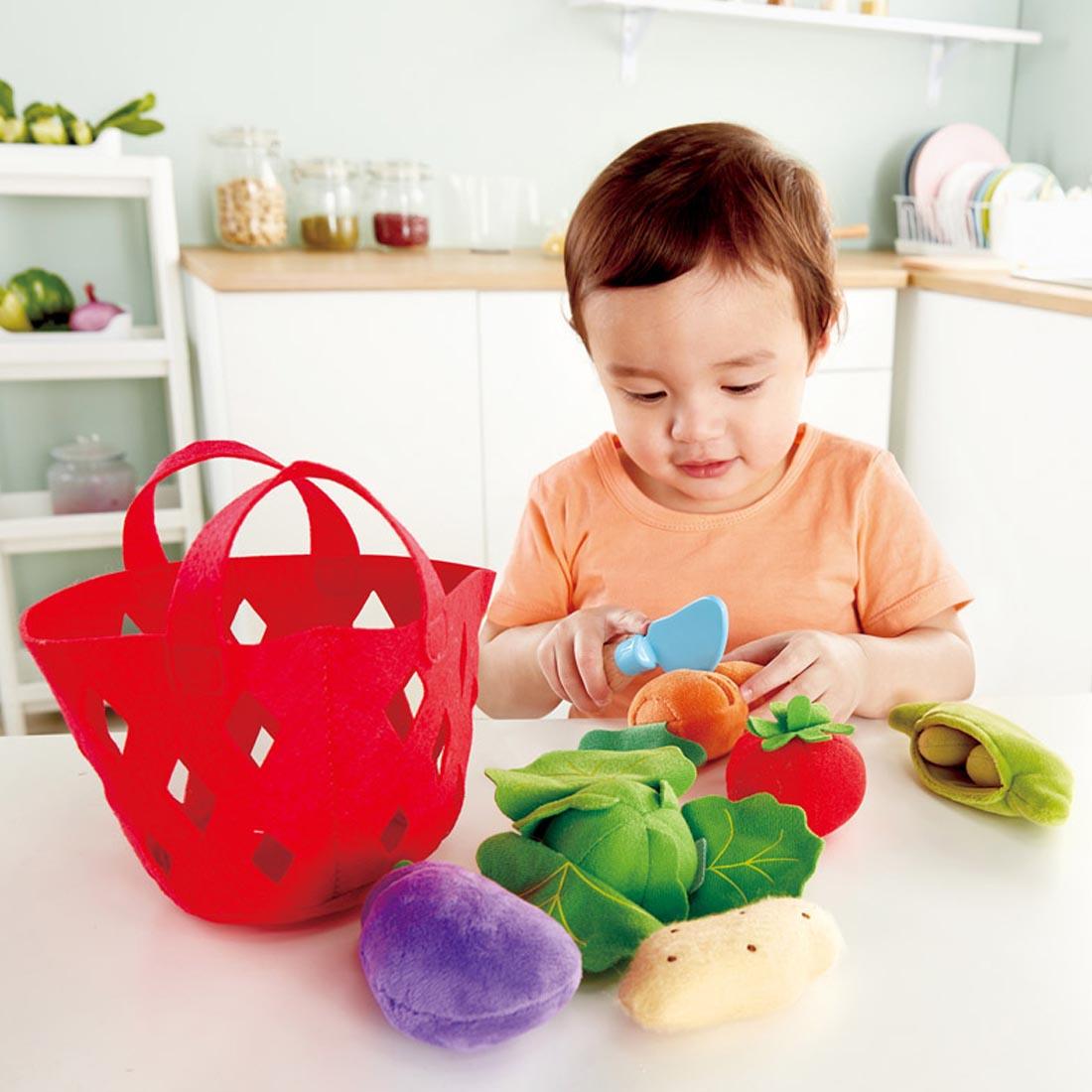 Child playing with the Toddler Vegetable Basket By Hape