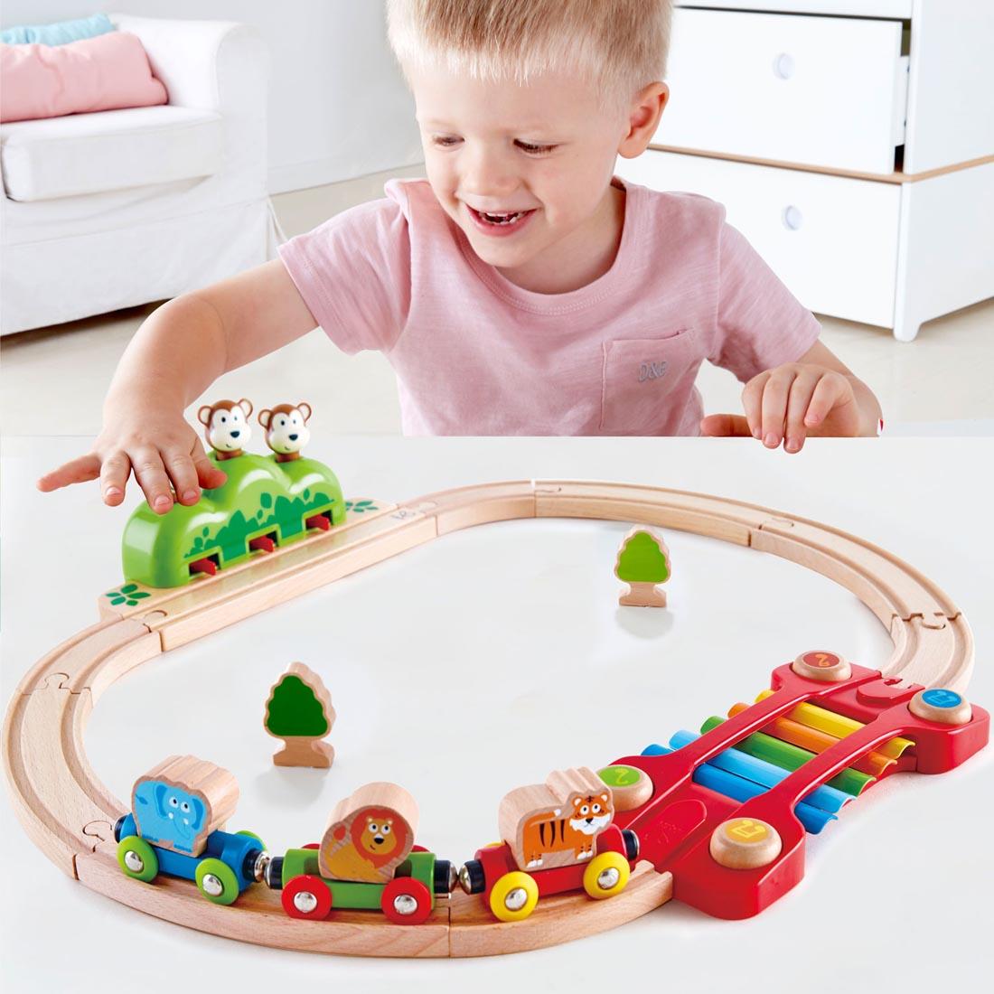 Child playing with the Music And Monkeys Railway By Hape