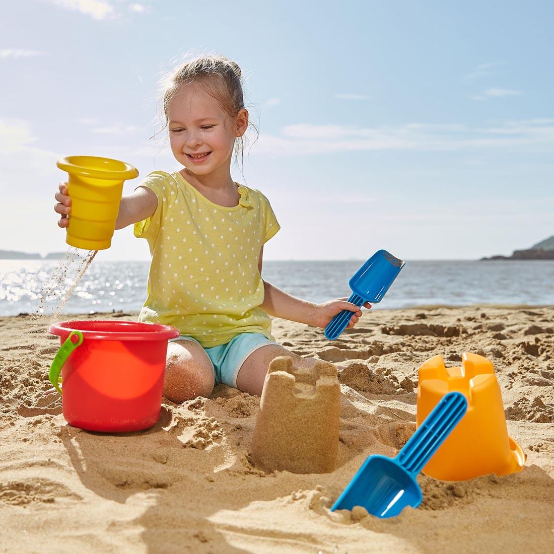 Child at the beach playing with the 5-In-1 Beach Set By Hape