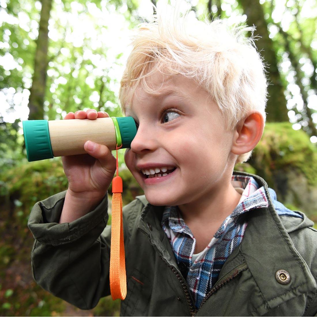 Child outdoors looking through the Adjustable Telescope By Hape