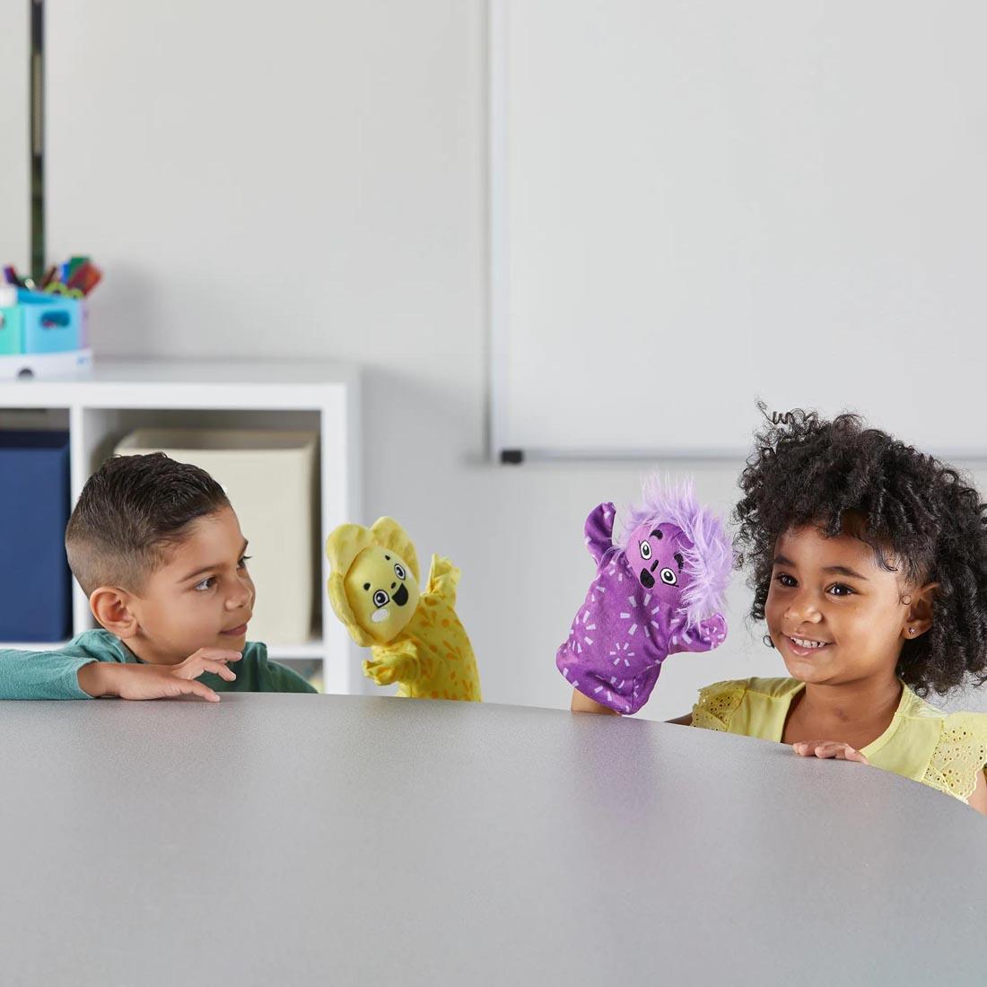 children playing with two of the Feelings Family Hand Puppets