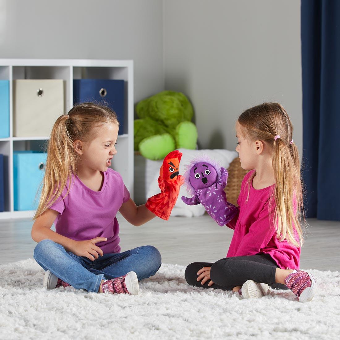 children playing with two of the Feelings Family Hand Puppets