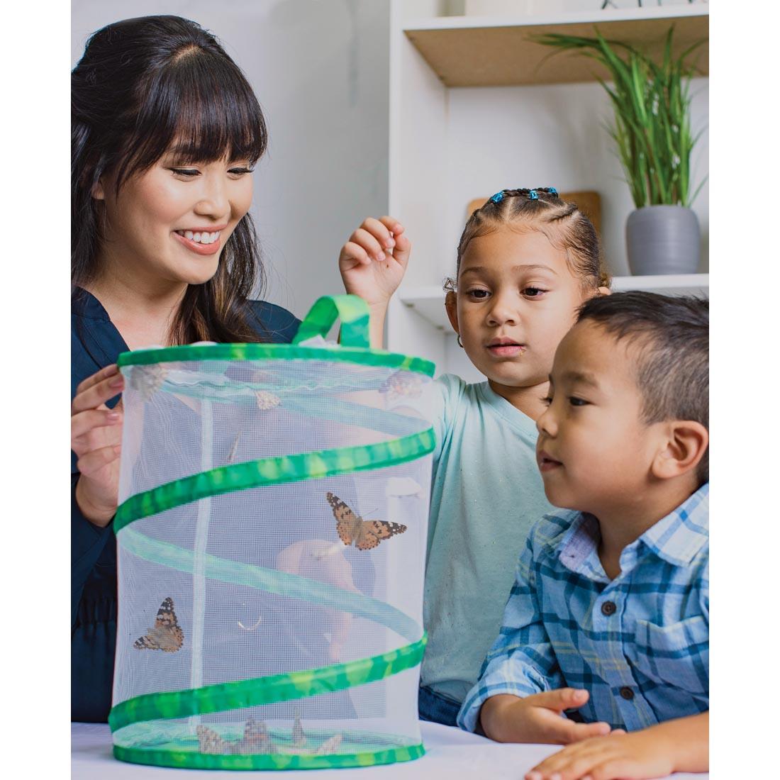 Woman with 2 children looking at the Live Butterfly Garden, which is filled with butterflies
