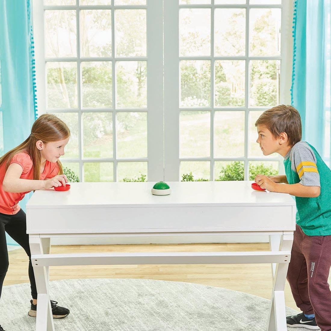 2 kids standing at a table playing the Super Mario Hover Shell Strike Game