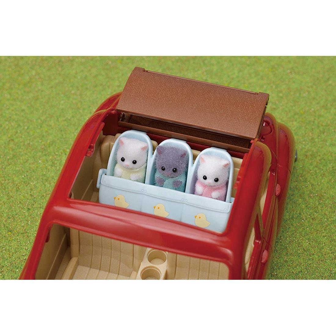 Calico Critters Triplets Stroller turned car seat shown in the back of a car