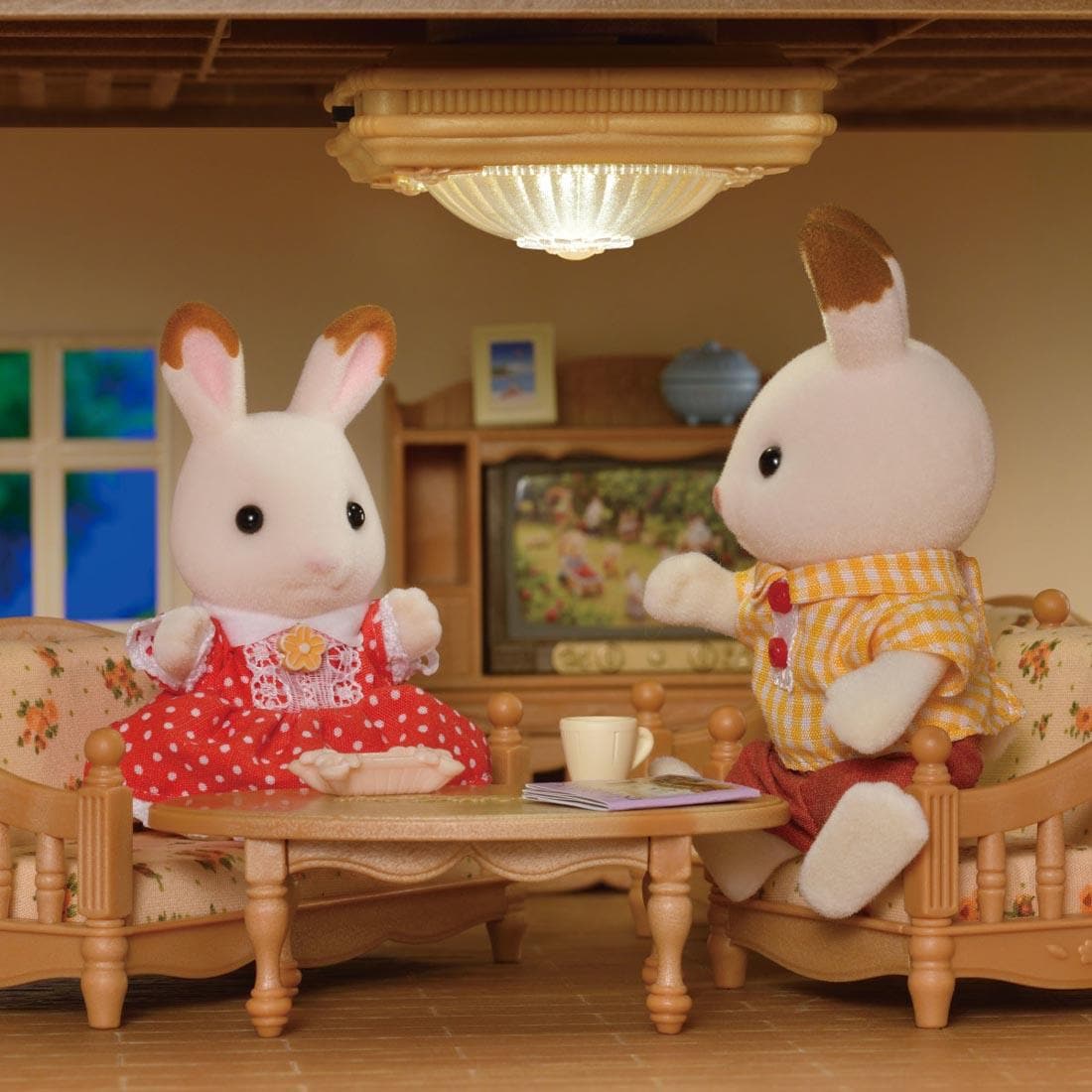 2 Calico Critters sitting on furniture under a Calico Critters Ceiling Light