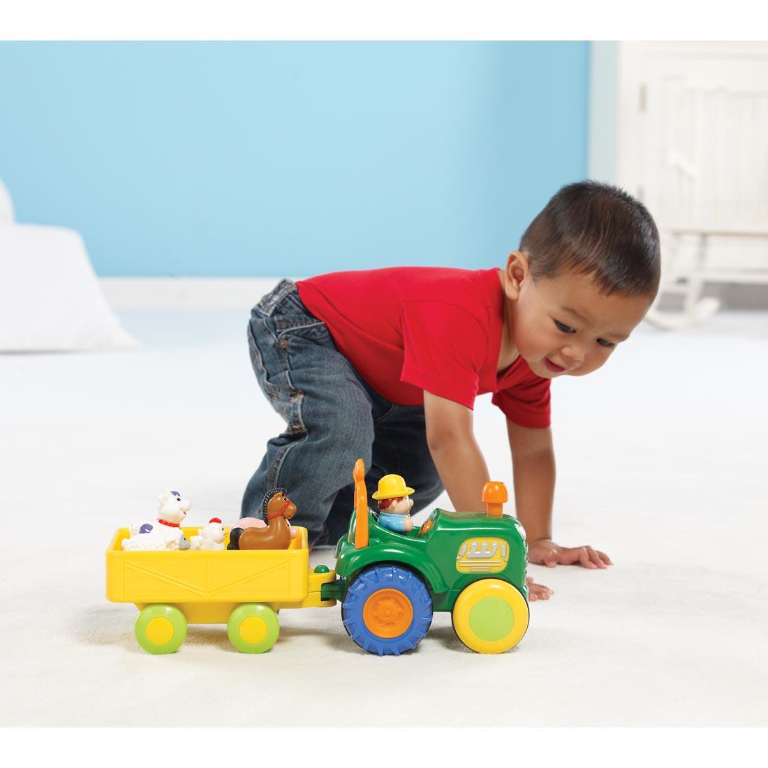 Child on the floor with the Kidoozie Funtime Tractor