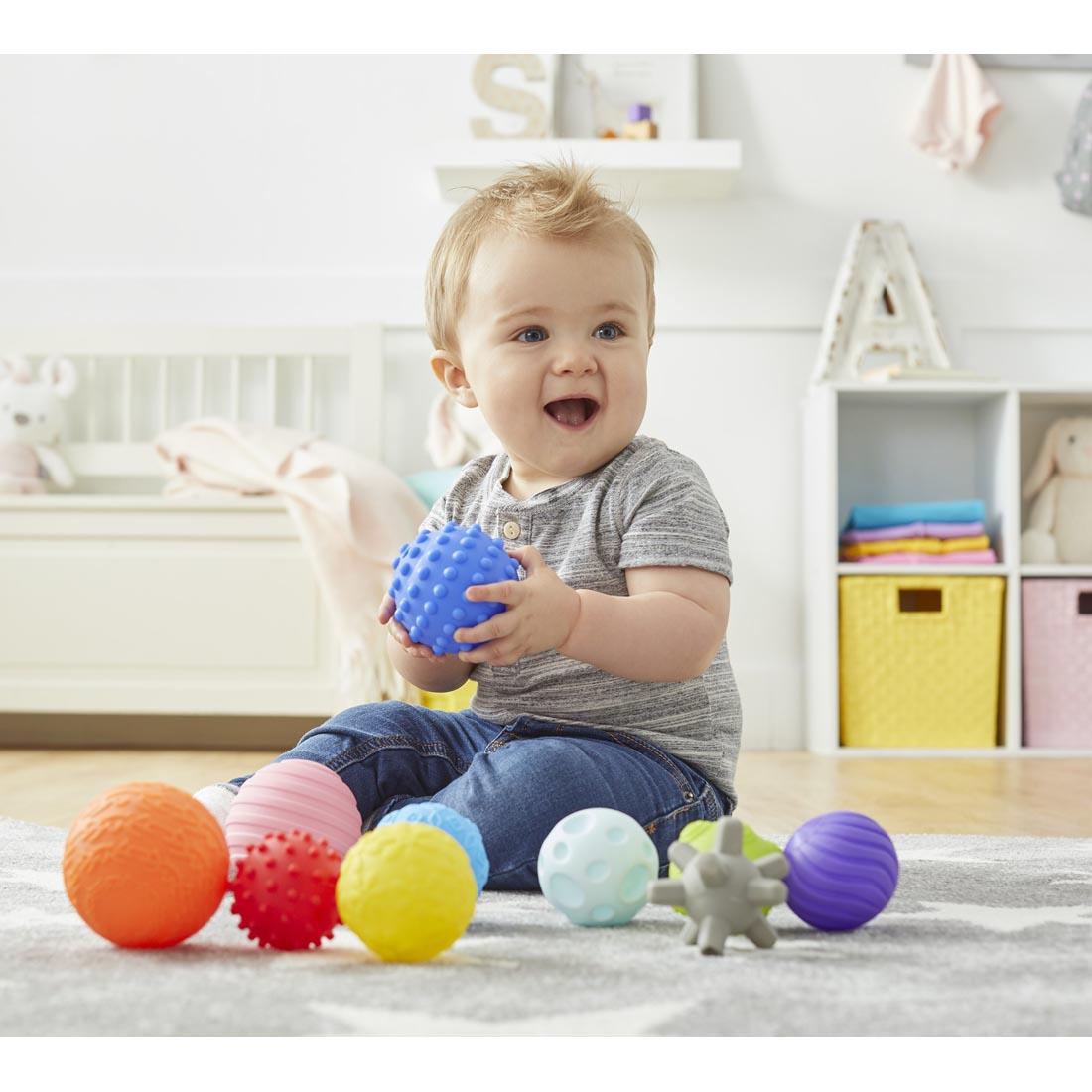 Child on the floor with Kidoozie Touch 'n Roll Sensory Balls