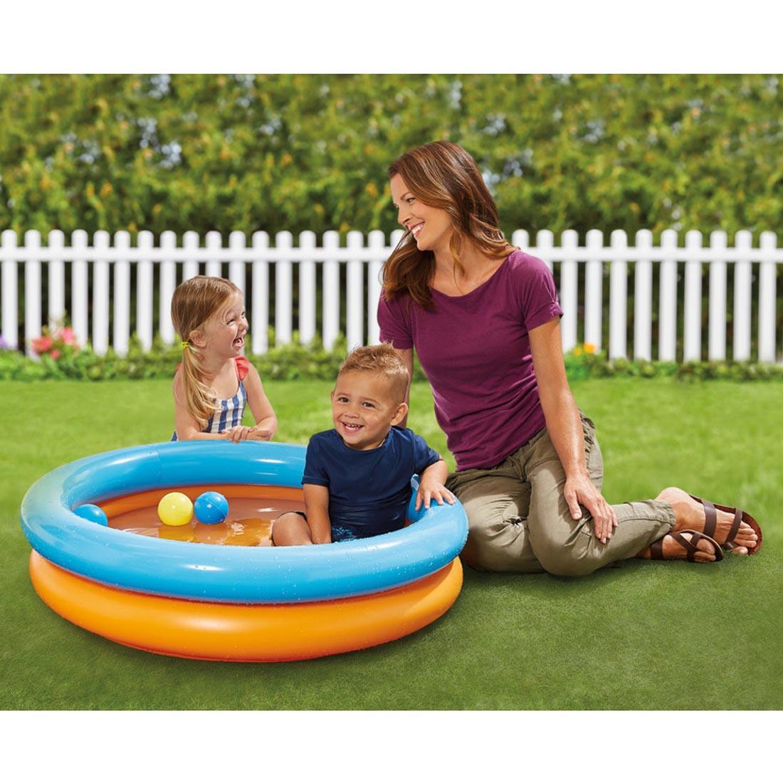 Two children and an adult outside with the 2-In-1 Ball Pit & Pool By Kidoozie