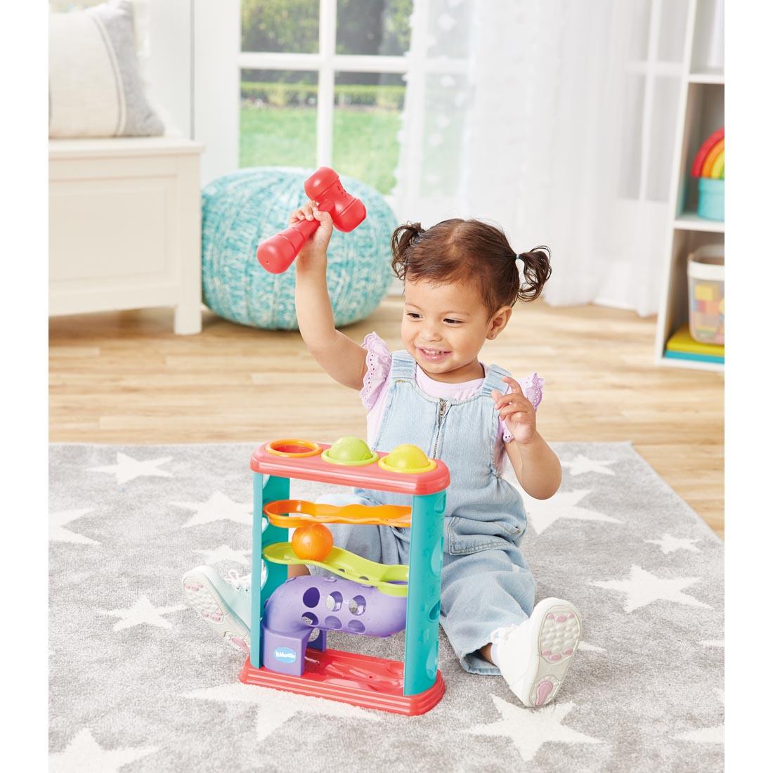 Child sitting down playing with the Pound-A-Ball Tower By Kidoozie