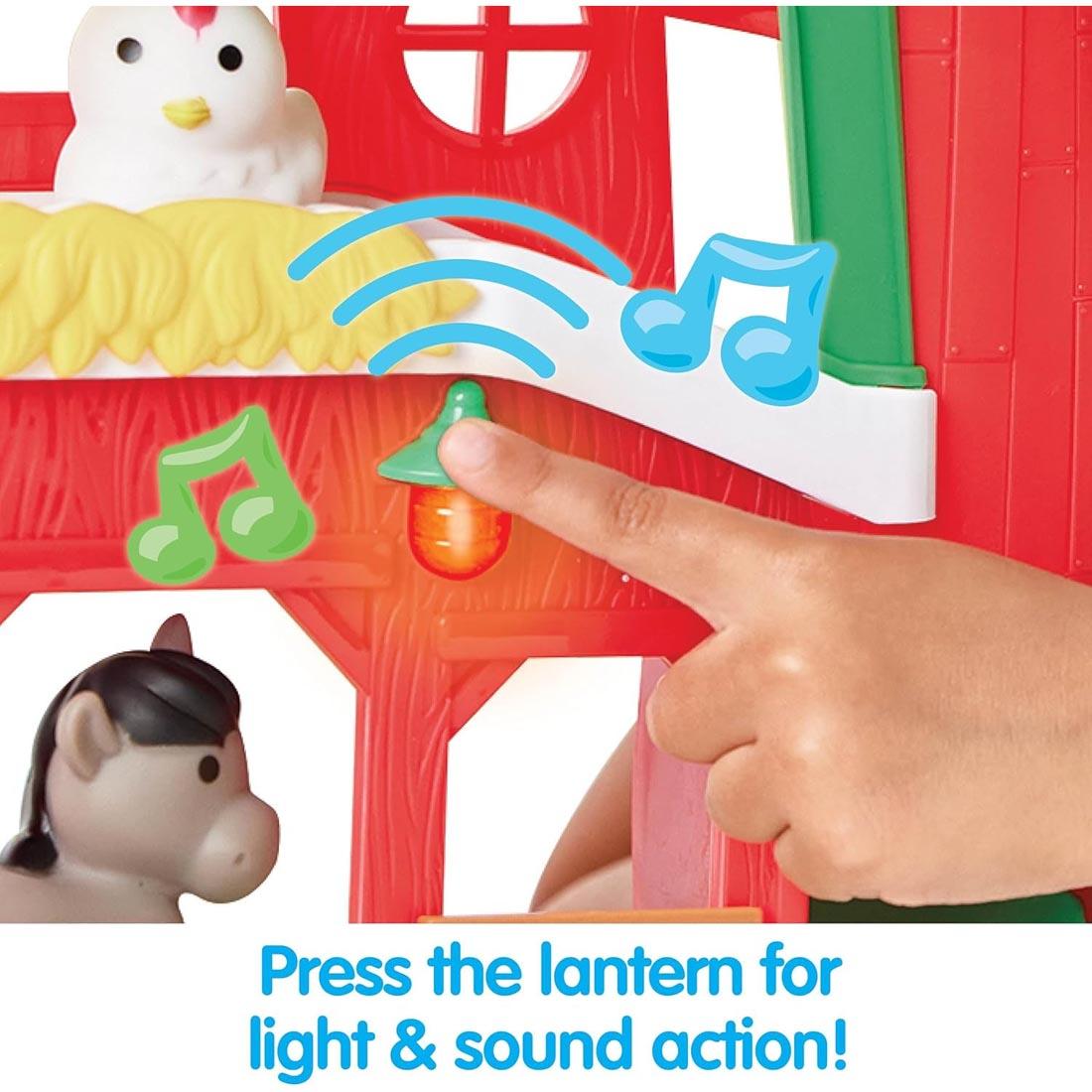 hand playing with the Barnyard Farm Playset By Kidoozie plus text Press the lantern for light & sound action!