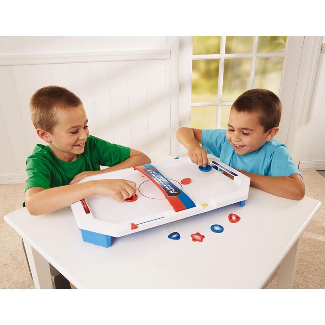 2 children playing with the Electronic Table-Top Air Hockey Set