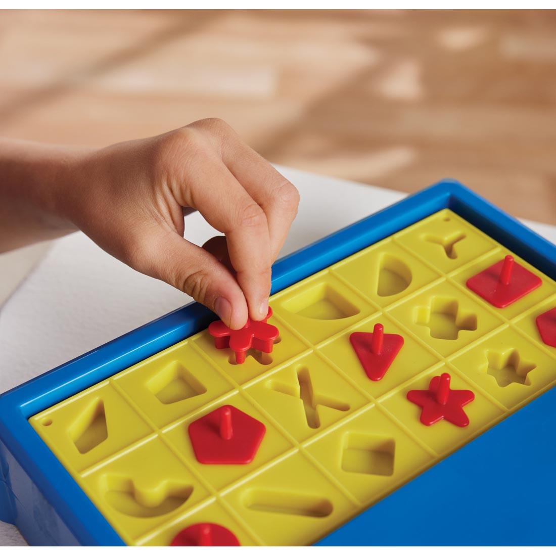 hand putting a piece into the Poppin' Puzzlers Game By Game Zone